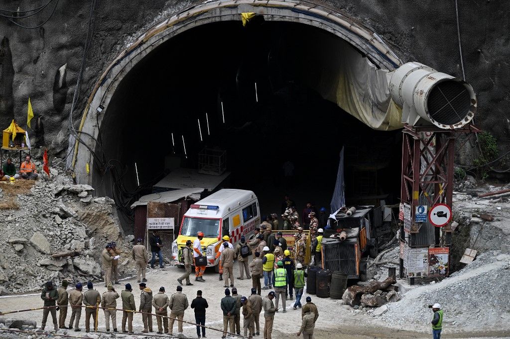 An ambulance and rescue operatives gather near the face of the collapsed under construction Silkyara tunnel in the Uttarkashi district of India's Uttarakhand state, on November 28, 2023. Indian rescue teams digging by hand are on the verge of breaking through to reach 41 men trapped in a collapsed road tunnel, officials said Tuesday, raising hopes the end of the marathon 17-day operation is in sight. (Photo by Sajjad HUSSAIN / AFP)