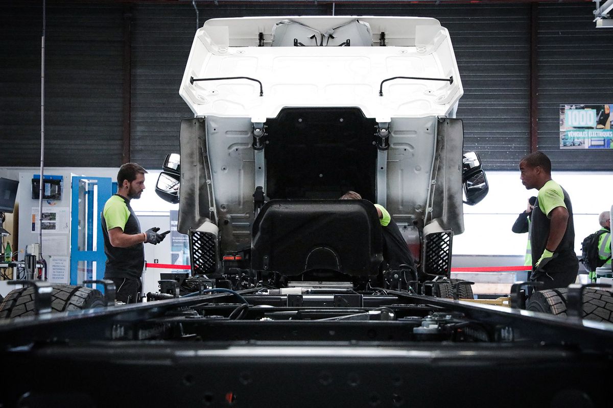 Employees work on an electric Renault truck, during a media tour of the Blainville-sur-Orne's Renault Truck factory, in Colombelles, near Caen, northwestern France, on August 30, 2023. Since March 2020, the Renault Trucks factory in Blainville has hosted the mass production of medium-tonnage electric trucks and has since produced more than 1,500 electric trucks of 16, 19 and 26 tonnes. (Photo by LOU BENOIST / AFP)