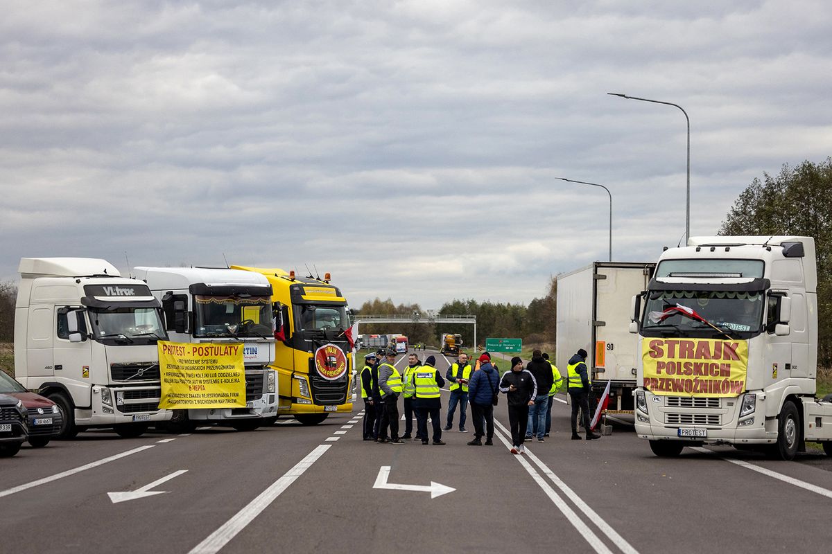 Transport company owners stand together as they with their vehicles block access to the Polish-Ukrainian border crossing in Dorohusk, Poland on November 6, 2023 to protest against 'unfair' competition. Several dozen owners of transport companies on November 6 blocked three major Polish border crossings with Ukraine in protest at what they say is unfair competition from the neighbouring country's businesses. Trucks lined up at the border checkpoint in Dorohusk, with almost all cargo traffic blocked by protesters who blamed the liberalisation of European Union rules for the slump in their revenues. (Photo by Wojtek Radwanski / AFP)