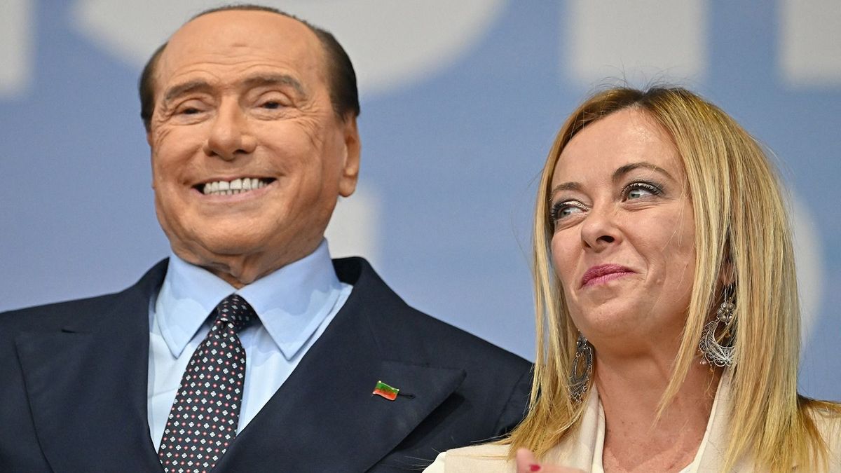 Forza Italia leader Silvio Berlusconi and Brothers of Italy leader Giorgia Meloni stand on stage on September 22, 2022 during a joint rally of Italy's right-wing parties Brothers of Italy (Fratelli d'Italia, FdI), the League (Lega) and Forza Italia at Piazza del Popolo in Rome, ahead of the September 25 general election. (Photo by Alberto PIZZOLI / AFP)