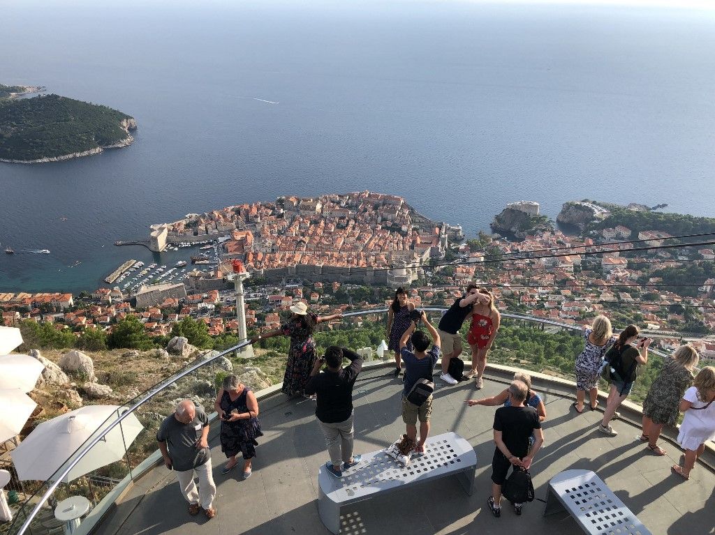 Tourists take selfies with a panoramic view of Dubrovnik on September 13, 2018. (Photo by Daniel SLIM / AFP)