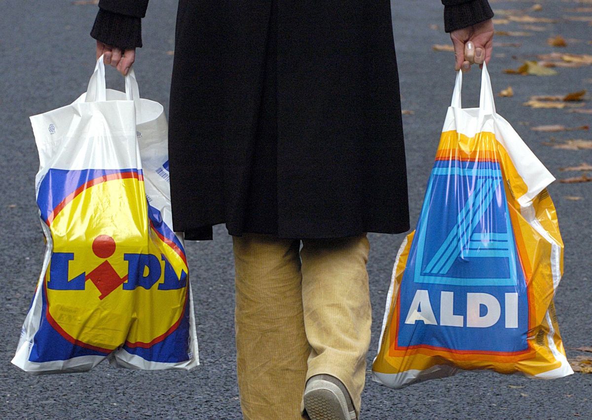 Lidl competes against Aldi - the Swabians quickly gain a share of the market
A woman carries one plastic bag of the discounter "Lidl" and one of "Aldi" in Cologne on 17 November 2003. Germany's second-biggest discounter Lidl is no longer overshadowed by the industry's number one Aldi. (Photo by Oliver Berg/picture alliance via Getty Images)
