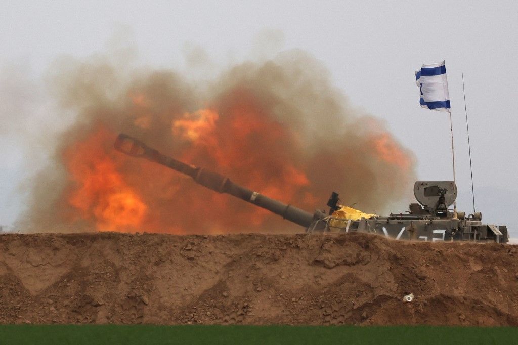 A picture taken in southern Israel near the border with the Gaza Strip on December 21, 2023, shows an Israeli artillery firing towards Gaza amid continuing battles between Israel and the militant group Hamas. (Photo by JACK GUEZ / AFP)