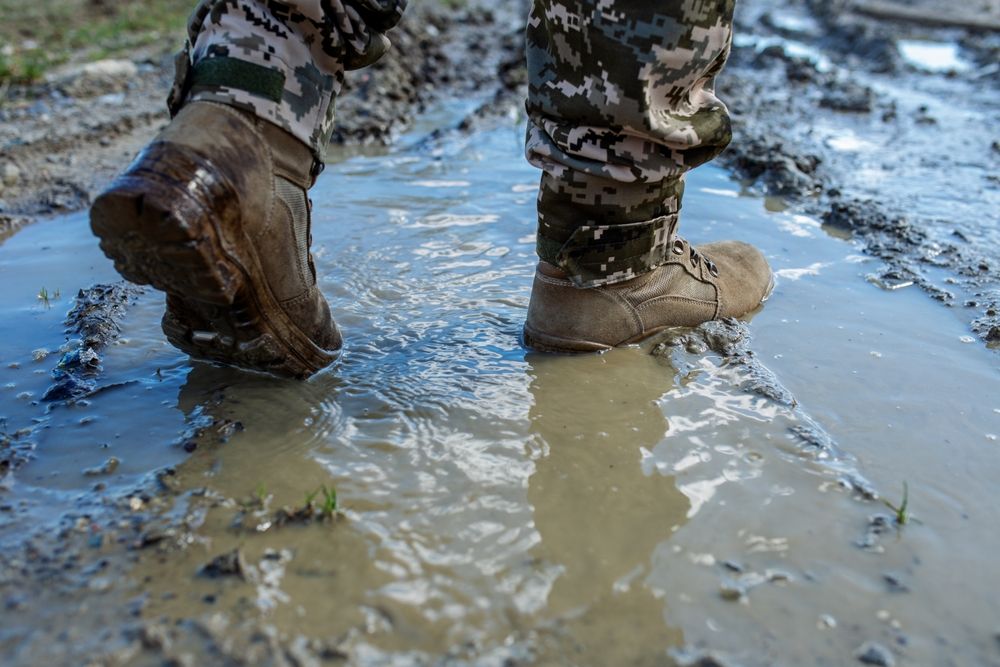 Brown,Military,Boots,On,Mud,And,Puddle.,Armed,Forces,Of