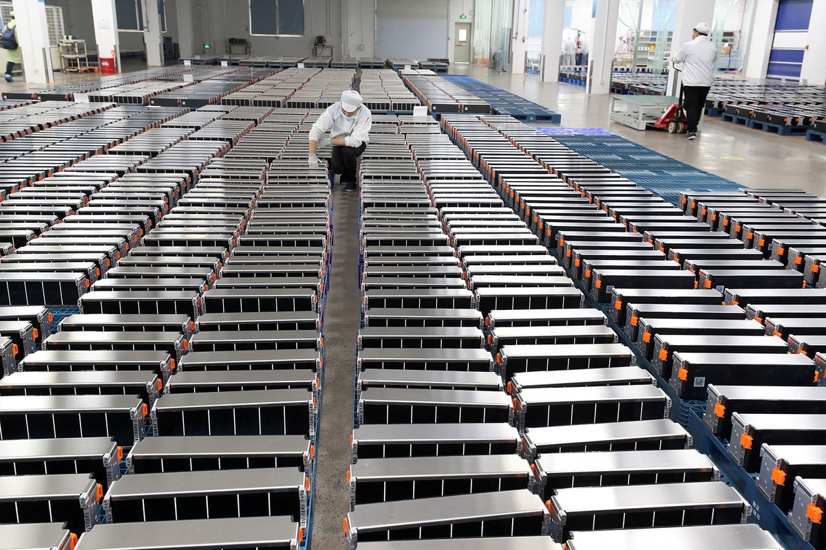 vám
This photo taken on March 12, 2021 shows a worker with car batteries at a factory for Xinwangda Electric Vehicle Battery Co. Ltd, which makes lithium batteries for electric cars and other uses, in Nanjing in China's eastern Jiangsu province. (Photo by AFP) / China OUT
