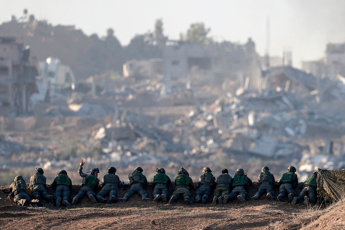 A picture taken in southern Israel near the border with the Gaza Strip on December 11, 2023, shows Israeli army soldiers keeping position on a hill overlooking northern Gaza, amid continuing battles between Israel and the militant group Hamas. (Photo by Menahem KAHANA / AFP)