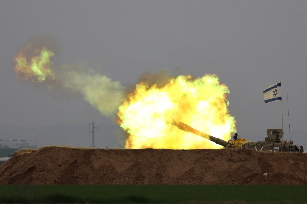 A picture taken in southern Israel near the border with the Gaza Strip on December 21, 2023, shows an Israeli artillery firing towards Gaza amid continuing battles between Israel and the militant group Hamas. (Photo by JACK GUEZ / AFP)