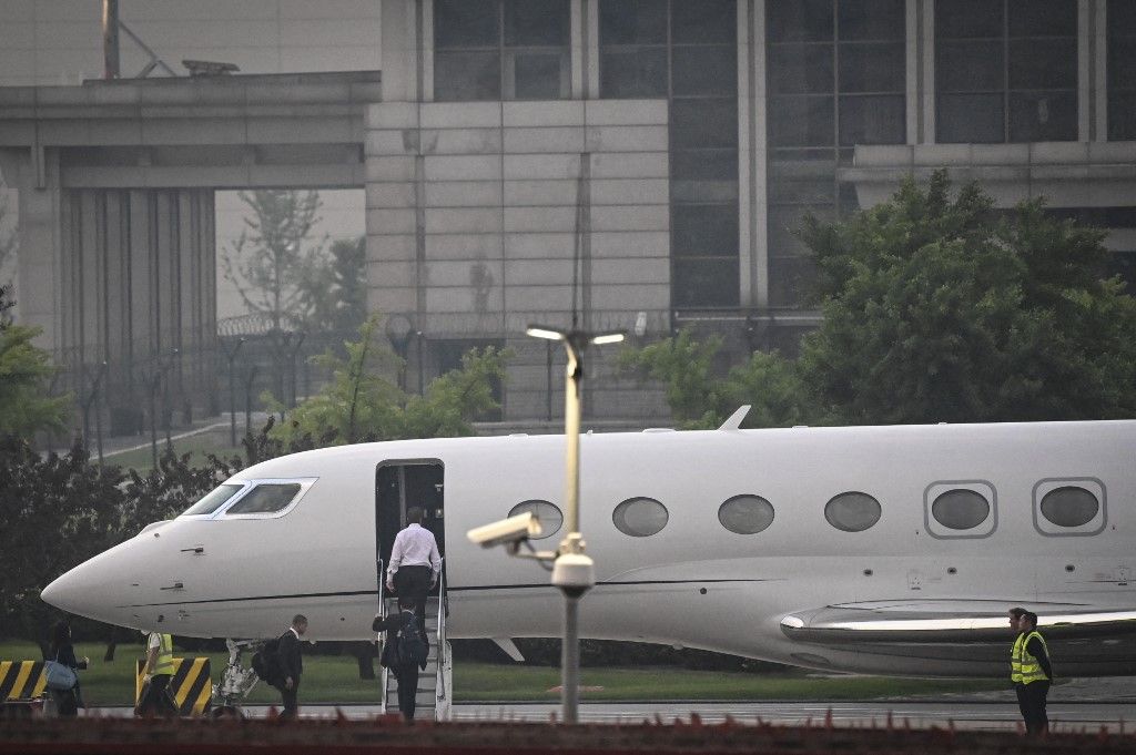 Tesla Chief Executive Officer Elon Musk (in white) boards his private jet before departing from Beijing Capital International Airport on May 31, 2023. Musk praised China's "vitality and promise" on May 31, Beijing said, during a trip to the Chinese capital in which he has met multiple government officials and reportedly declared he will expand his business there. (Photo by Jade Gao / AFP)