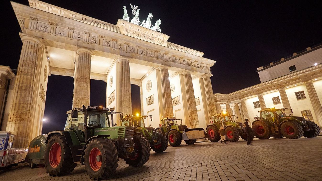 17 December 2023, Berlin: Farmers from Ostholstein stand with their tractors in front of the Brandenburg Gate. Hundreds of farmers have made their way to Berlin to demonstrate against the planned stop to agricultural diesel subsidies. Photo: Jörg Carstensen/dpa (Photo by Jörg Carstensen / DPA / dpa Picture-Alliance via AFP)