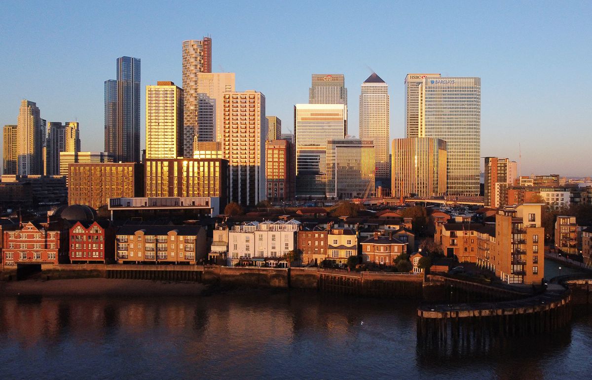 An aerial view of London's Canary Wharf financial district as the sun rises over the River Thames in London on November 4, 2020. England heads into a second national lockdown tomorrow to try to cut coronavirus cases. (Photo by Daniel LEAL / AFP)