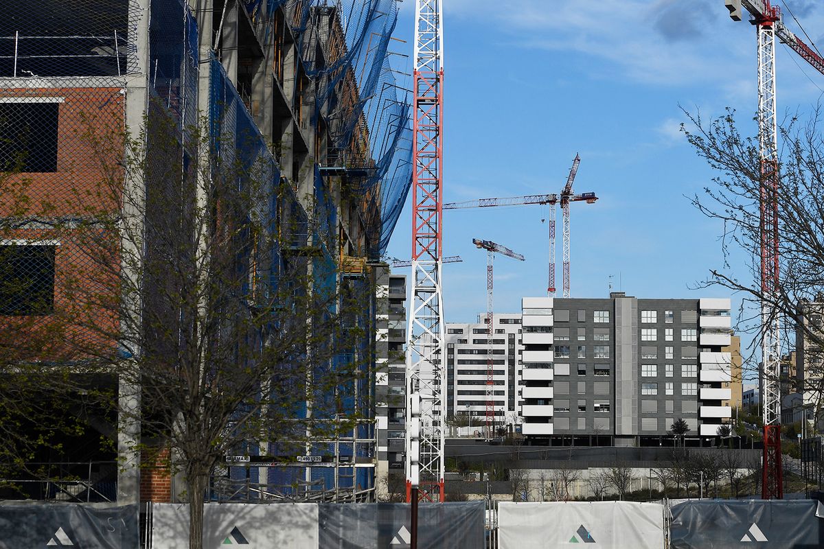 Cranes are pictured at a construction site in Madrid, on March 29, 2020,