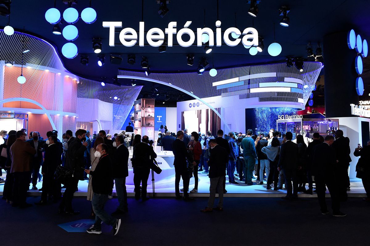 People visit the stand of Spanish multinational telecommunications company Telefonica in the MWC (Mobile World Congress) in Barcelona on March 2, 2022. One of the technology industry's biggest annual get-togethers is held in the Spanish city of Barcelona, under the shadow of Russia's invasion of Ukraine. The Mobile World Congress, where smartphone and telecoms companies show off their latest products and reveal their strategic visions, is expected to welcome more than 40,000 guests over its four-day run. (Photo by Josep LAGO / AFP)