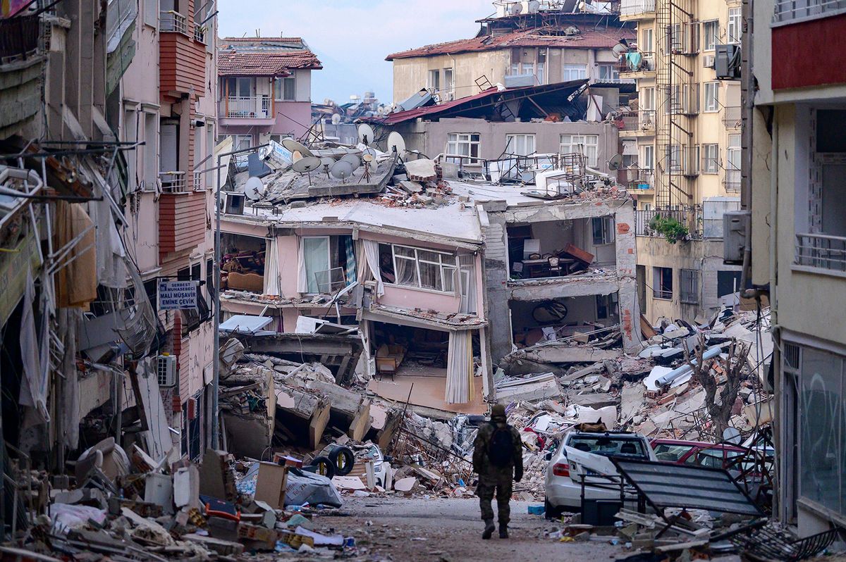 -- AFP PICTURES OF THE YEAR 2023 --A Turkish soldier walks among destroyed buildings in Hatay, on February 12, 2023, after a 7.8-magnitude earthquake struck the country's south-east.. The death toll from a massive earthquake that hit Turkey and Syria climbed to more than 20,000 on February 9, 2023, as hopes faded of finding survivors stuck under rubble in freezing weather. (Photo by Yasin AKGUL / AFP) / AFP PICTURES OF THE YEAR 2023
