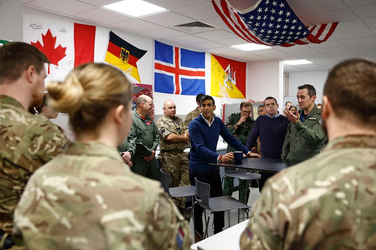 Britain's Prime Minister Rishi Sunak (C) walks with Scottish Conservative leader Douglas Ross (3R) and Station Commander Group Captain Jim Lee (2R) as he speaks with RAF military personnel during his visit to Royal Air Force (RAF) base Lossiemouth in Moray, north east Scotland on December 18, 2023, to recognise soldiers for their service. (Photo by Jeff J Mitchell / POOL / AFP)