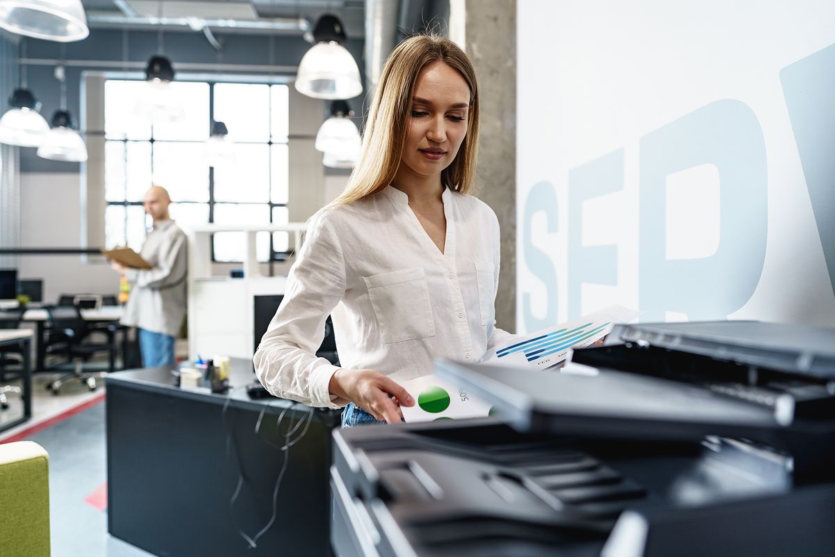 Young,Employee,Using,Modern,Printer,In,Office