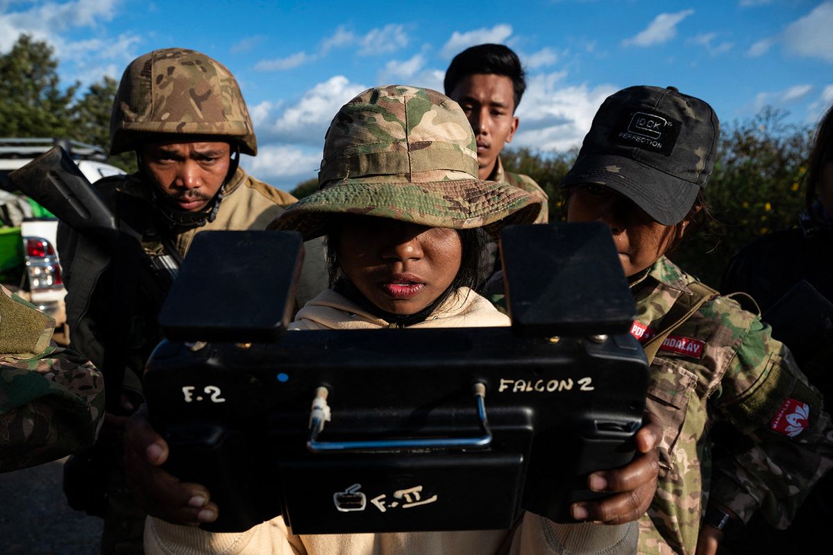 This photo taken on December 11, 2023 show a female member of the Mandalay People's Defence Forces (MDY-PDF) piloting a drone on the frontline amid clashes with Myanmar's military in northern Shan State. In the hills of northern Myanmar young women fly combat drones, treat wounded comrades and patrol the frontlines, new roles in the battle to overthrow the military junta. (Photo by AFP) / To go with 'MYANMAR-COUP-CONFLICT-WOMEN,FOCUS'