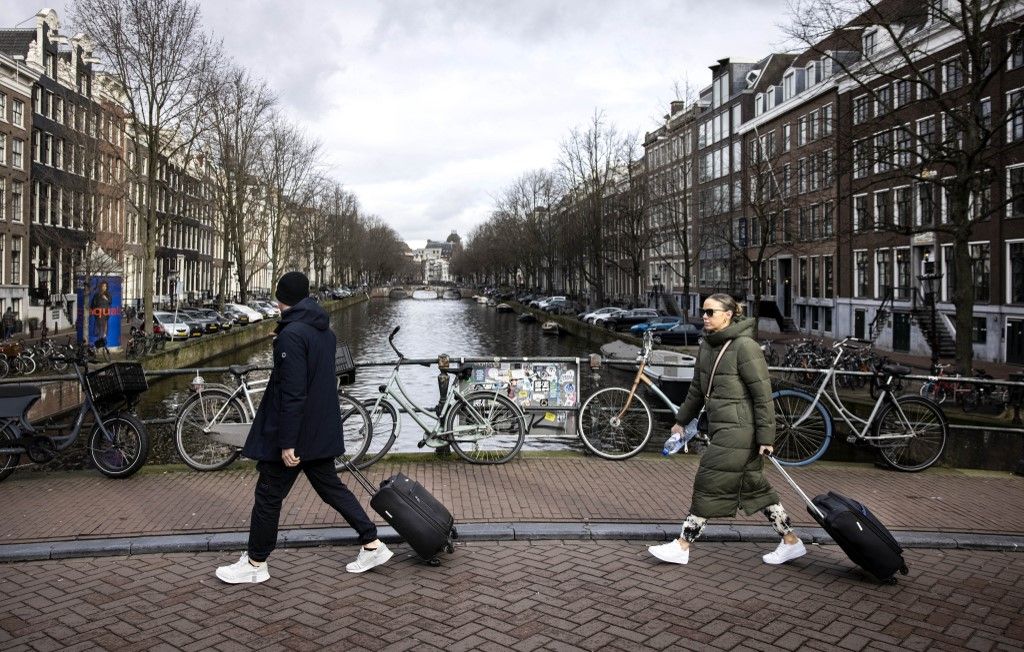 AMSTERDAM - Tourists walk with trolleys through the nine streets in Amsterdam. ANP RAMON VAN FLYMEN netherlands out - belgium out (Photo by Ramon van Flymen / ANP MAG / ANP via AFP)