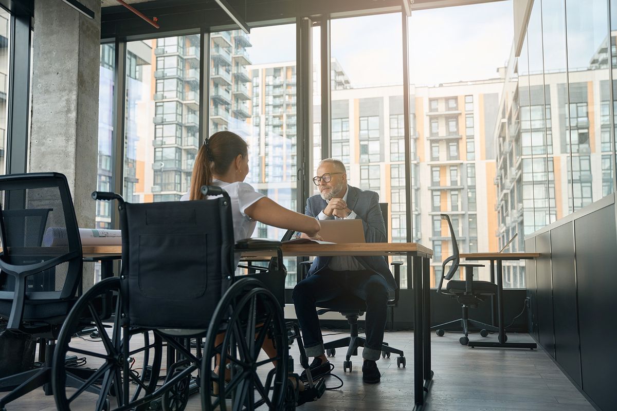 Businessman,And,Woman,In,Wheelchair,During,Interview,In,Office
