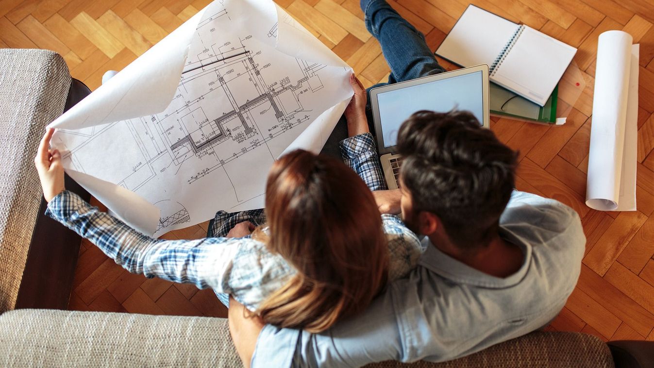 Young,Couple,Examining,Blueprints,Of,They,New,House.moving,House,Concept.Young couple examining blueprints of they new house.Moving house concept.