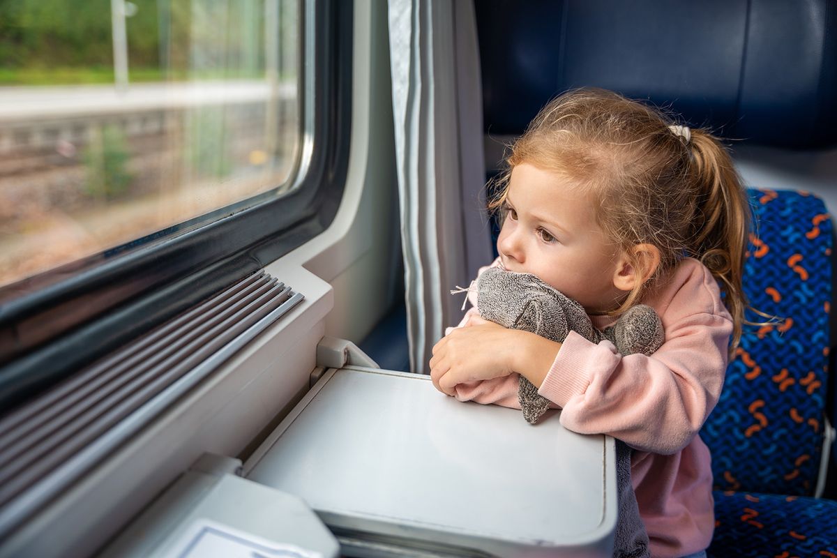 Beautiful,Little,Girl,With,Toy,Looking,Out,Train,Window,Outside,