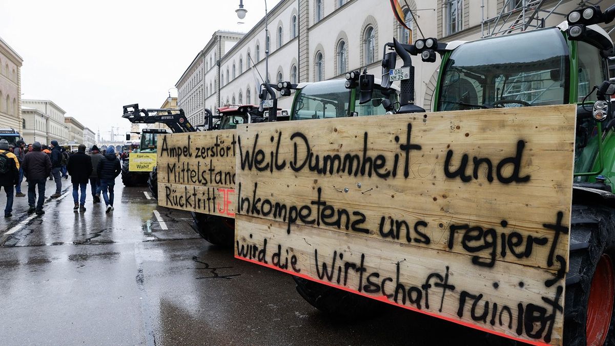 Farmers have attached a placard reading "As stupidity and incompetence rule us, the economy is ruined" (R) on a tractor standing among others at Odeonsplatz square in the city center to take part in protests against the federal government's austerity plans in Munich, southern Germany, on January 8, 2024. The German government on January 4, 2024 had dropped part of its plans to cut agricultural subsidies in the face of massive protests from farmers. Contrary to the initial plans, a discount on the vehicle tax for agricultural machinery would be maintained, the government's spokesman said in a statement. (Photo by MICHAELA REHLE / AFP)