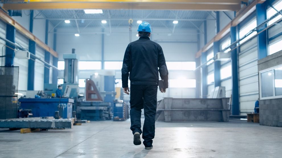 Factory,Worker,In,A,Hard,Hat,Is,Walking,Through,Industrial