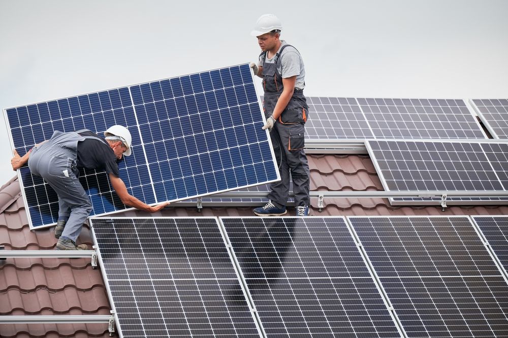 Men,Technicians,Carrying,Photovoltaic,Solar,Moduls,On,Roof,Of,House.