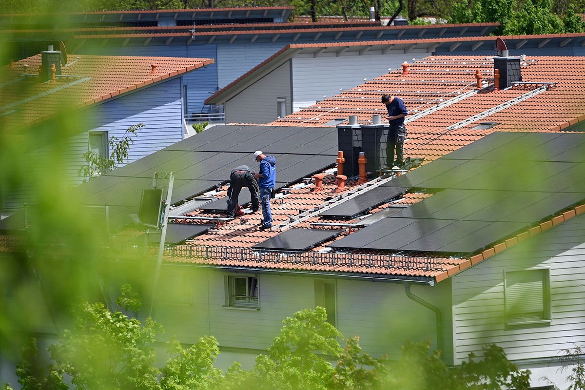 Installation of solar panels on a house roof.