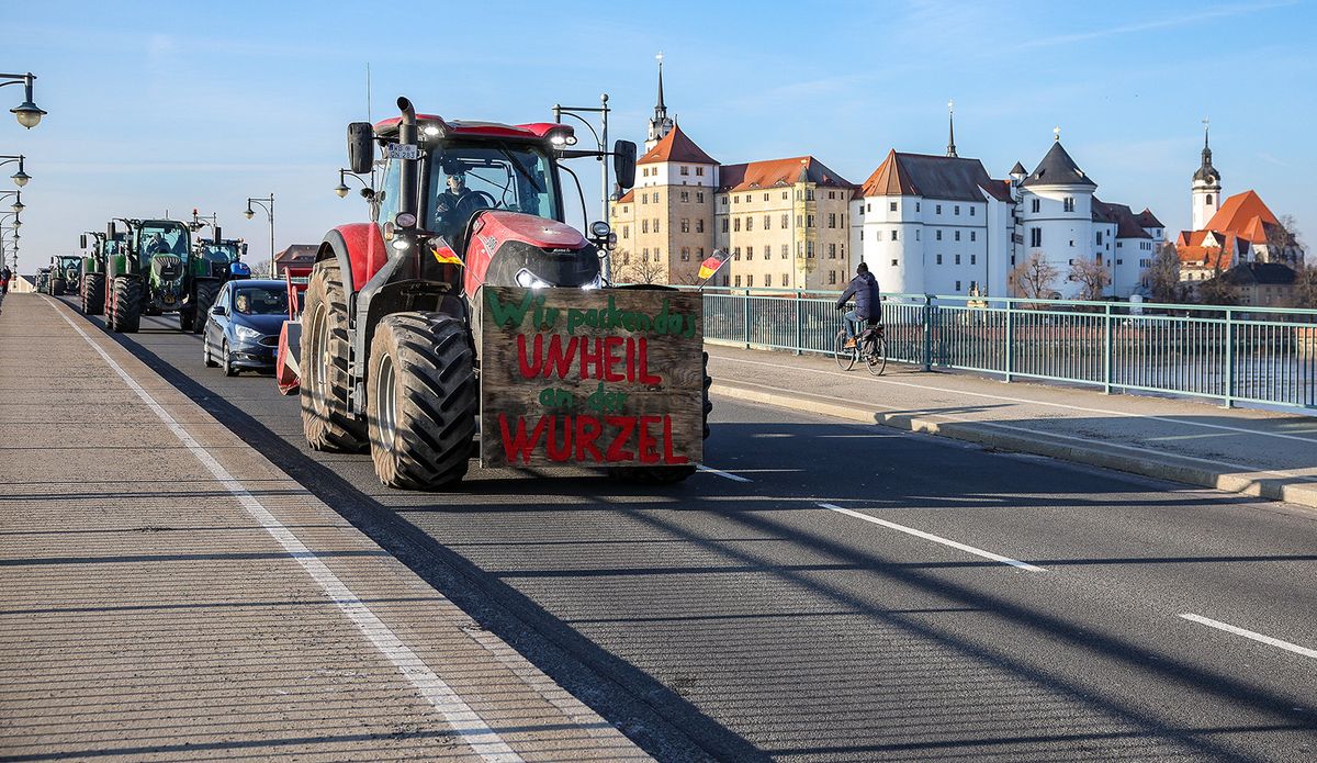 08 January 2024, Saxony, Torgau: "We'll get to the root of the problem" is written on the sign of a tractor during a blockade of the Elbe bridge. In response to the federal government's austerity plans, the farmers' association has called for a week of action with rallies and rallies starting on January 8. It is to culminate in a major demonstration in the capital on January 15. Photo: Jan Woitas/dpa (Photo by JAN WOITAS / DPA / dpa Picture-Alliance via AFP)