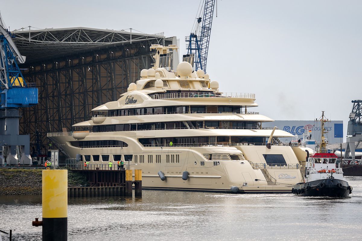 The super-yacht Dilbar is pulled into a covered floating dock of Luerssen shipyards on the Weser river at the harbour of Bremen on September 23, 2022. The 156-meter-yacht had stayed since October 2021 for repairs in dry dock at a German shipbuilding company at Hamburg's harbour, northern Germany, and is considered the world's biggest by tonnage. It is owned the Russian billionaire Alisher Usmanov, 68, who has been among dozens of Russian oligarchs hit by punishing Western sanctions over Russian President Vladimir Putin's invasion of Ukraine. (Photo by FOCKE STRANGMANN / AFP)