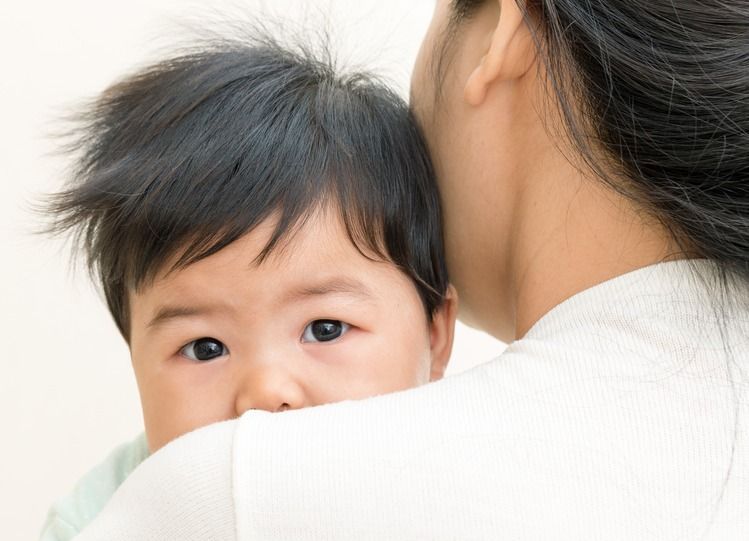 Adorable,Asian,Baby,Sick,And,Unhappy,On,Mom,Shoulder.