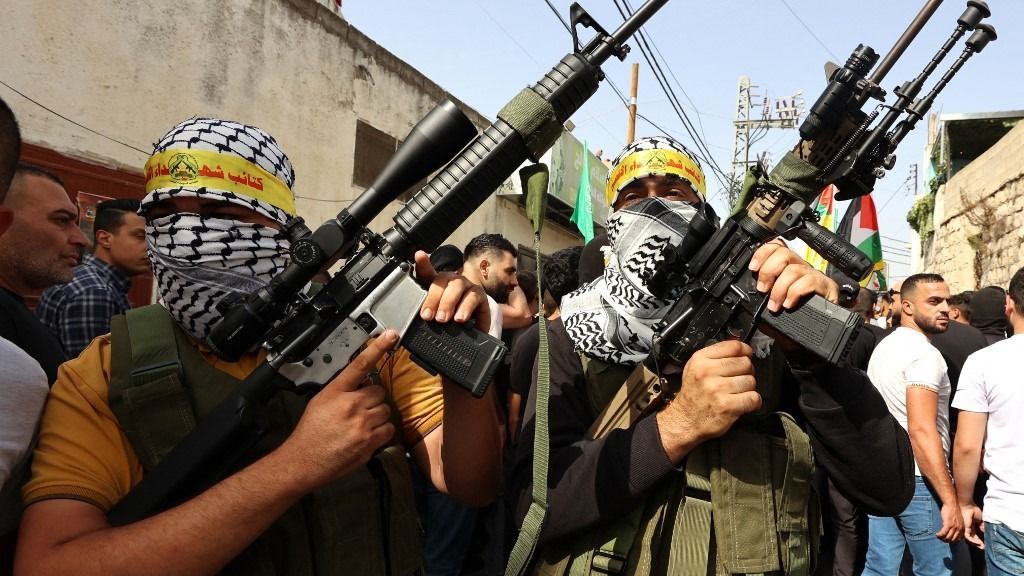 A masked Islamic Jihad fighter poses with a weapon at the Jenin camp in the West Bank on November 4, 2023, as violence surges in the occupied territory amid the ongoing battles between Israel and the Palestinian group Hamas in the Gaza Strip. (Photo by Aris MESSINIS / AFP) szankció