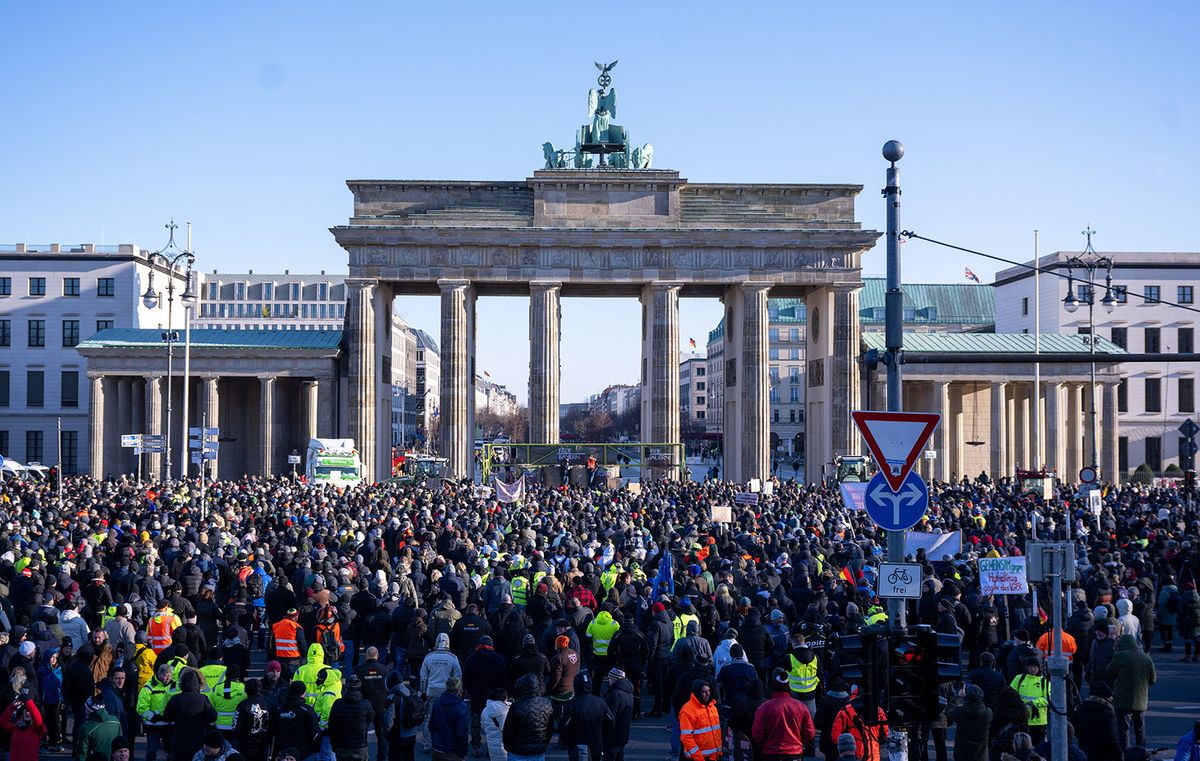 08 January 2024, Berlin: Numerous people stand in front of the Brandenburg Gate at the rally organized by the Association of Independent Farmers against subsidy cuts in the agricultural sector. In response to the federal government's austerity plans, the farmers' association has called for a week of action with rallies and rallies starting on January 8. It is to culminate in a major demonstration in the capital on January 15. Photo: Monika Skolimowska/dpa (Photo by Monika Skolimowska / DPA / dpa Picture-Alliance via AFP)