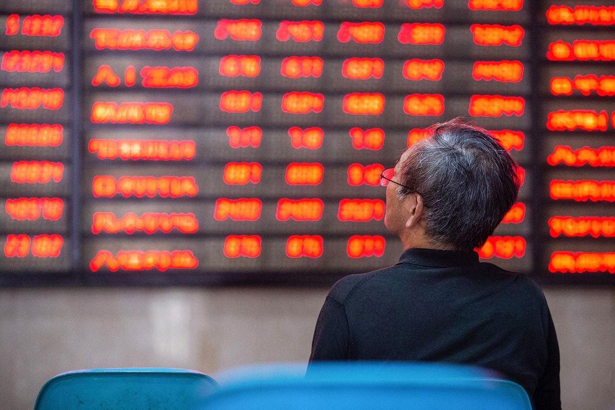 An investor looks at screens showing stock market movements at a securities company in Nanjing in China's eastern Jiangsu province on July 6, 2020. Shanghai stocks surged on July 6 to a more than two-year high as investors piled in following a combination of rosy predictions for the market and strong economic data. (Photo by AFP) / China OUT, kína