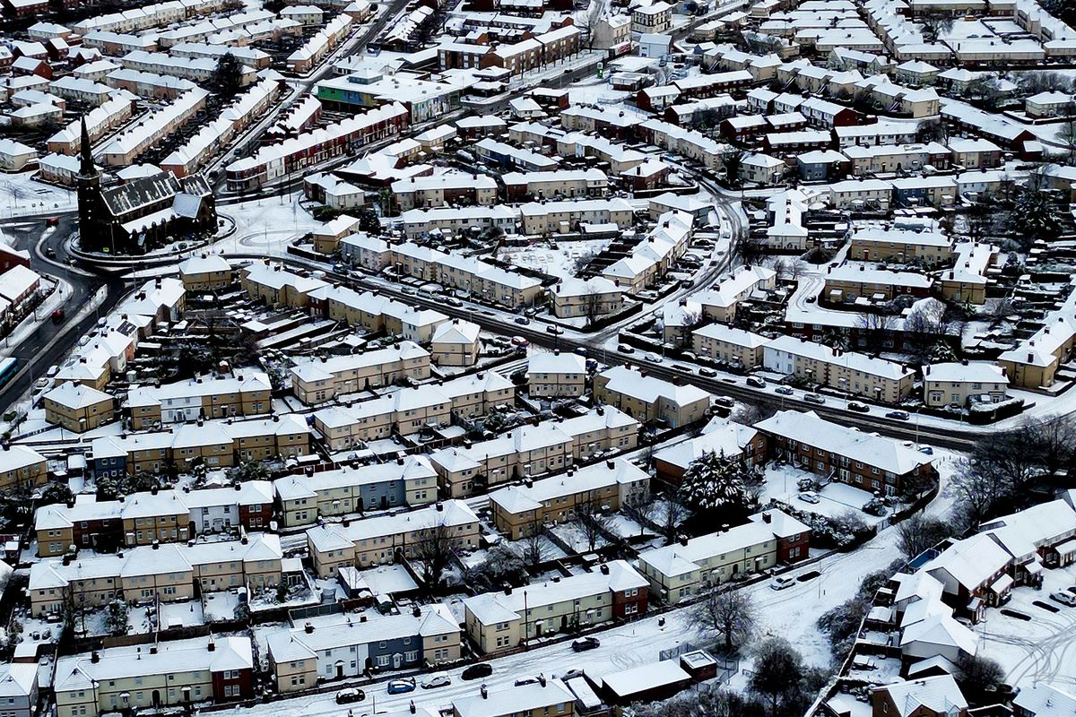 An aerial view shows snow covering St James Church and houses in Birkenhead, northwest England, on January 16, 2024. (Photo by Paul ELLIS / AFP)