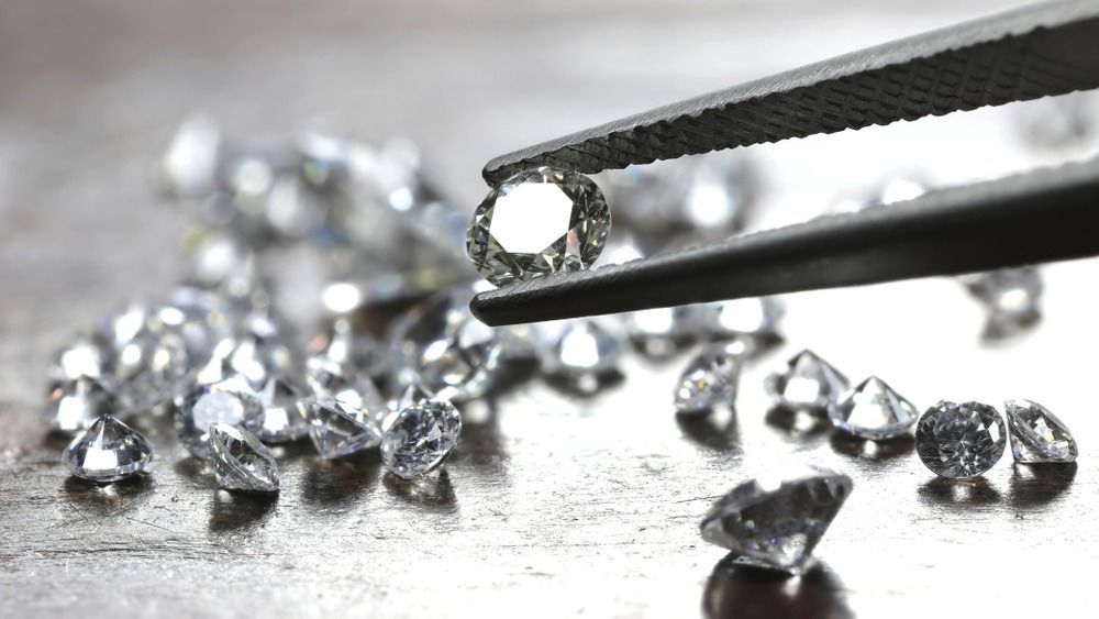 Brilliant,Cut,Diamond,Held,By,Tweezers gyémánt