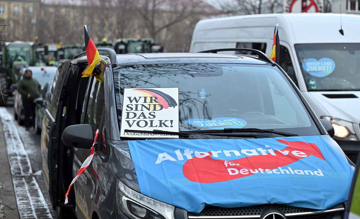 08 January 2024, Thuringia, Erfurt: "We are the people" is written on a poster on a vehicle covered with an AfD flag during a blockade of the Juri-Gagarin-Ring. In response to the federal government's austerity plans, the farmers' association has called for a week of action with rallies and rallies starting on January 8. It is to culminate in a major demonstration in the capital on January 15. Photo: Martin Schutt/dpa (Photo by MARTIN SCHUTT / DPA / dpa Picture-Alliance via AFP)