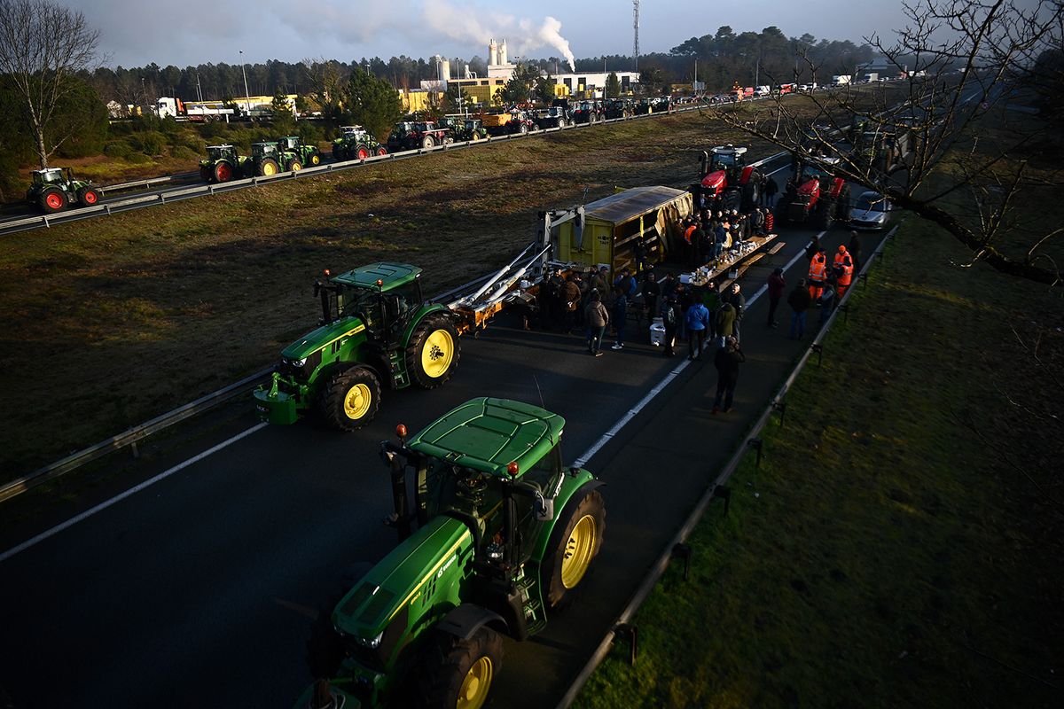 Farmers gather and block the A63 motorway with their tractors in Mios, near the bassin d'Arcachon, southwestern France, on January 31, 2024. Convoys of tractors edged closer to Paris, Lyon and other strategic locations in France on January 31, as thousands of protesting farmers appeared to ignore warnings of police intervention if they cross red lines laid down by ministers. Farmers' unions, unimpressed by concessions offered by the president's government, encouraged their members to fight on for higher incomes, less red tape and protection from foreign competition. (Photo by Christophe ARCHAMBAULT / AFP)