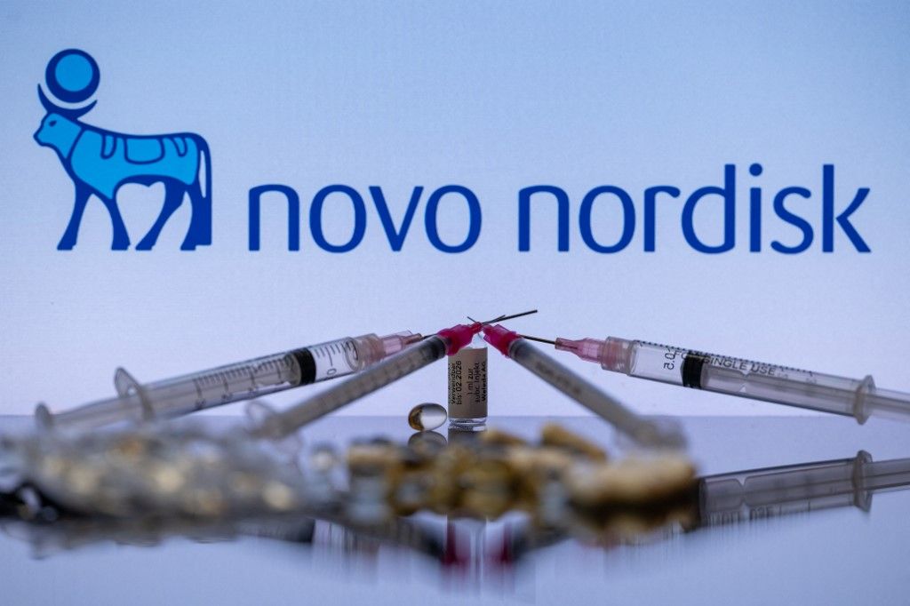 Novo Nordisk - Ozempic - Photo IllustrationThe Novo Nordisk pharmaceutical logo is being displayed on a screen alongside pills and a medical vial with a syringe in this photo illustration, taken in Brussels, Belgium, on December 3, 2023. (Photo by Jonathan Raa/NurPhoto) (Photo by Jonathan Raa / NurPhoto / NurPhoto via AFP)
