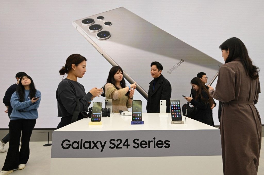 This picture taken on January 15, 2024 shows people looking at Samsung Galaxy S24 series smartphones displayed during a media preview event at a Samsung store in Seoul. (Photo by Jung Yeon-je / AFP)