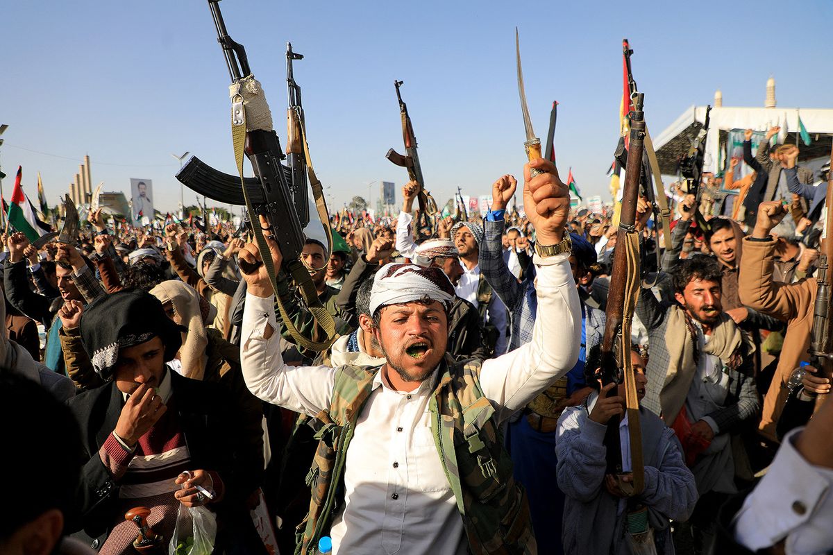 Huthi fighters brandish their weapons during a protest following US and British forces strikes, in the Huthi-controlled capital Sanaa on January 12, 2024 amid the ongoing battles between Israel and the militant Hamas group in Gaza. US and British forces struck rebel-held Yemen early on January 12, after weeks of disruptive attacks on Red Sea shipping by the Iran-backed Huthis who say they act in solidarity with Gaza. The pre-dawn air strikes add to escalating fears of wider conflict in the region, where violence involving Tehran-aligned groups in Yemen as well as Lebanon, Iraq and Syria has surged since the Israel-Hamas was began in early October. (Photo by MOHAMMED HUWAIS / AFP)