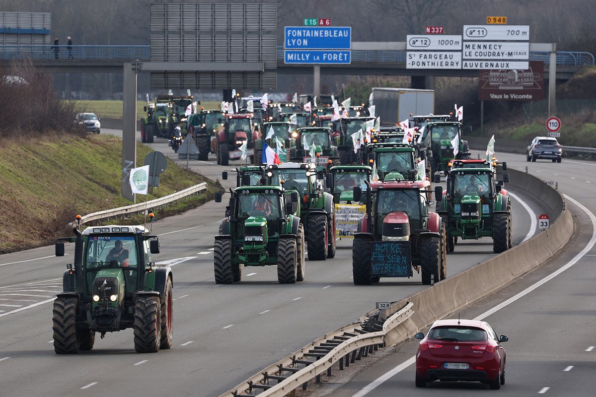 French farmers drive tractors to take part in road block protests on the A6 highway near Ormoy, south of Paris, on January 29, 2024, amid nationwide protests called by several farmers unions on pay, tax and regulations. Local branches of major farmer unions FNSEA and Jeunes Agriculteurs announced on January 27, 2024, a "siege of the capital for an indefinite period" starting at 2 p.m. on January 29, 2024, as some farmers deem the government's announcements in favor of the sector are insufficient. (Photo by EMMANUEL DUNAND / AFP)