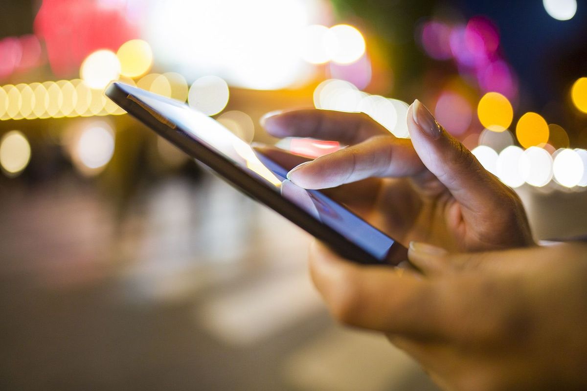 Woman,Using,Her,Mobile,Phone,In,The,Street,,Night,Light