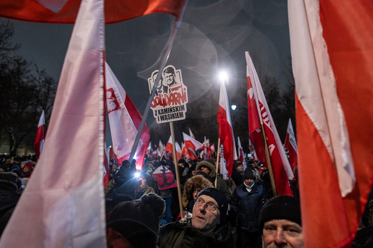 Supporters of the Law and Justice (PiS) party protest against the restructuring of the public media launched by the government, as they hold a banner reading "Solidarity with Kaminski and Wasik", in Warsaw, Poland, on January 11, 2024. (Photo by Wojtek Radwanski / AFP)
