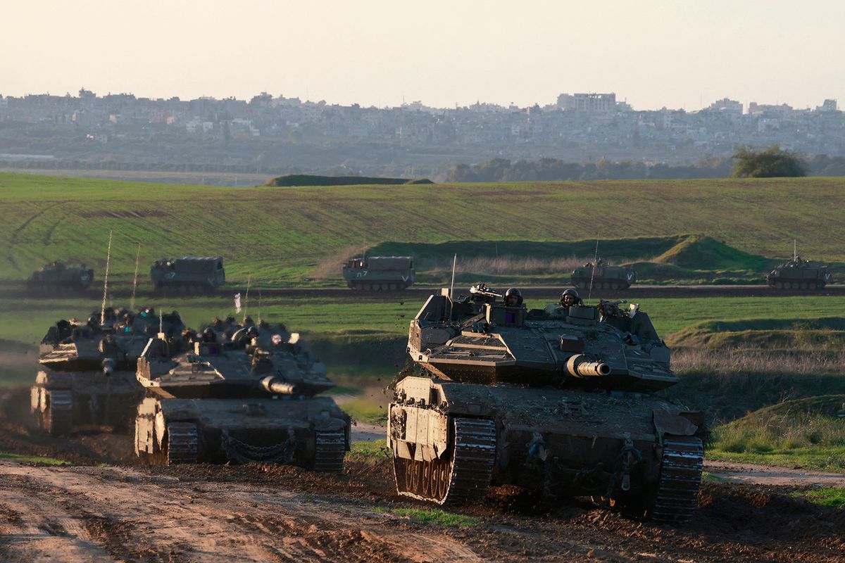 A picture taken from the Israeli border with Gaza shows an Israeli armoured vehicle convoy after returning from the Palestinian territory on January 15, 2024, amid ongoing battles between Israel and the Palestinian Hamas militant group. (Photo by Menahem KAHANA / AFP)