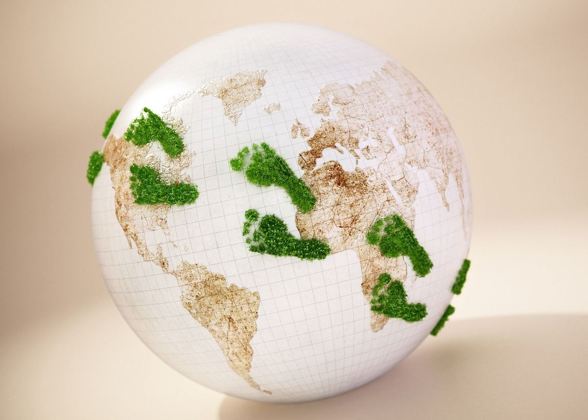 Green footprints on the globe. Copy space on the right.