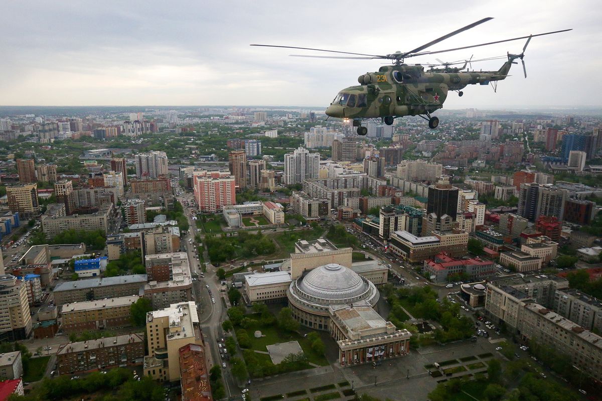 Russian Mi-8 helicopters fly over Novosibirsk during a rehearsal for the Victory Day parade on May 7, 2020. President Vladimir Putin had planned a major celebration for this year's 75th anniversary of the victory over Nazi Germany during World War Two, with world leaders in attendance as thousands of troops and tanks paraded through Red Square. The coronavirus forced him to postpone the parade and the day will now be marked only with military aircraft flying over major cities. (Photo by Rostislav NETISOV / AFP)