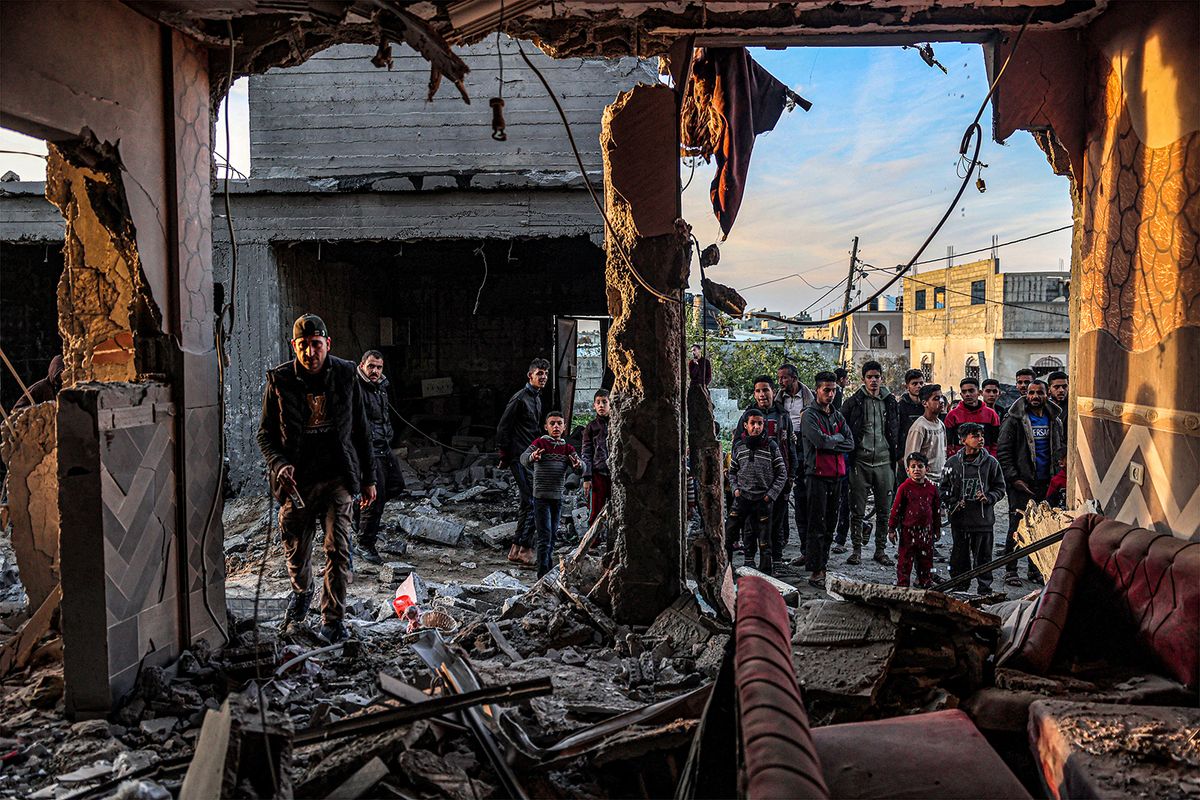 People inspect debris and rubble in a building heavily damaged by Israeli bombardment, in Rafah in the southern Gaza Strip on February 11, 2024, amid the ongoing conflict between Israel and the Palestinian militant group Hamas. (Photo by SAID KHATIB / AFP)