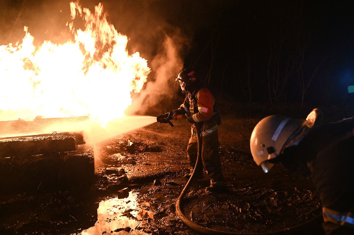 Ukrainian emergency personnel douse water to extinguish flames as they work at the site of a drone attack in Kharkiv, early on February 10, 2024. Seven people, including three children, were killed Saturday in a Russian drone attack on the city of Kharkiv in eastern Ukraine, the regional governor said. "Unfortunately the death toll from the occupiers' attacks on Kharkiv has risen to seven," Oleg Synegubov said on the Telegram social network. "Among them are three children: 7, 4 years old and a baby about six months old." (Photo by SERGEY BOBOK / AFP)