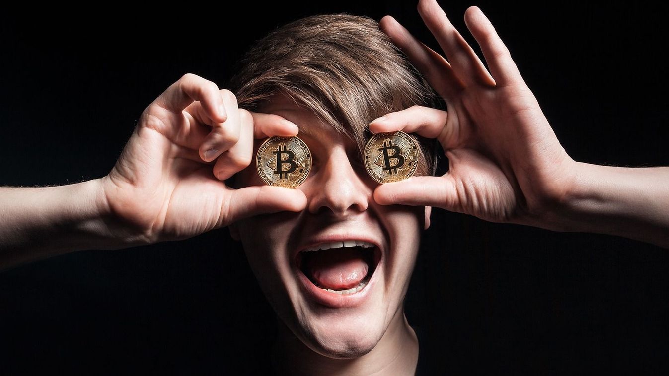 crazy bitcoin lover with golden coin by eyes; funny miner with btc near face; 